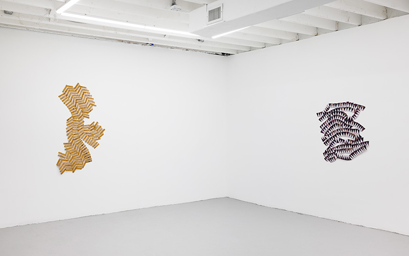 Fabric artworks in a white-walled gallery