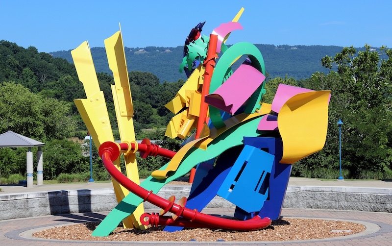 large public art sculpture with colorful geometric shares made of metal